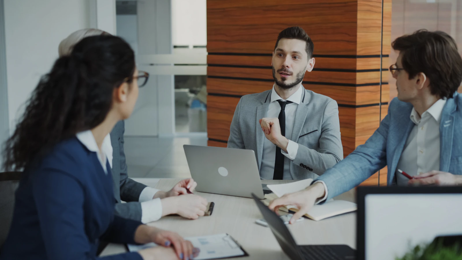 Business professionals collaborate around a table, representing the enterprise workflows connected by Atlassian and OpenAI.